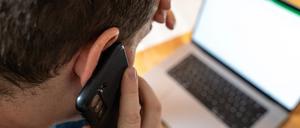 Bavaria, Germany - November 24, 2023: Man at work in the office. Phone calls with the smartphone, stress and burnout concept *** Mann bei der Arbeit im Büro. Telefonieren mit dem Smartphone, Stress und Burnout Konzept