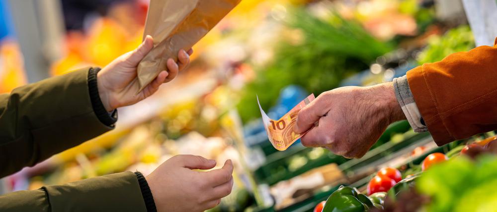 ARCHIV - 22.11.2023, Bremen: An einem Marktstand wird mit Bargeld eingekauft. (zu dpa: «Inflation zu Jahresbeginn auf niedrigstem Stand seit Juni 2021») Foto: Sina Schuldt/dpa +++ dpa-Bildfunk +++