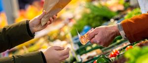 ARCHIV - 22.11.2023, Bremen: An einem Marktstand wird mit Bargeld eingekauft. (zu dpa: «Inflation zu Jahresbeginn auf niedrigstem Stand seit Juni 2021») Foto: Sina Schuldt/dpa +++ dpa-Bildfunk +++
