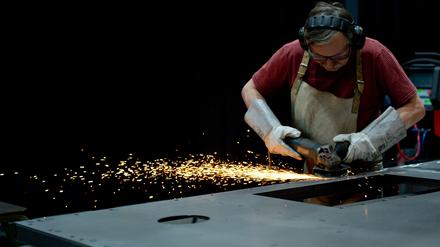Ein Mitarbeiter der ThyssenKrupp Aufzugswerke schleift am 17.11.2014 in Neuhausen auf den Fildern (Baden-Württemberg) Metall mit einem Trennschleifer ab, damit es später an den Schweißnähten besser lackiert werden kann. 