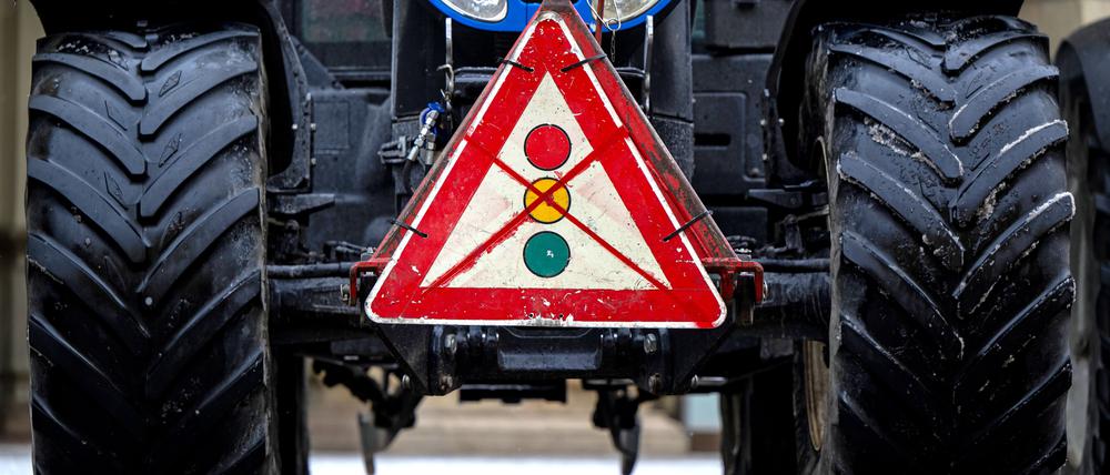 ARCHIV - 08.01.2024, Bayern, München: Ein durchgestrichenes Verkehrsschild mit einer Ampel hängt während einer Demonstration von Landwirten an einem Traktor. (zu dpa: «Fahrzeugkorso von Landwirten mit rund 250 Fahrzeugen») Foto: Lennart Preiss/dpa +++ dpa-Bildfunk +++