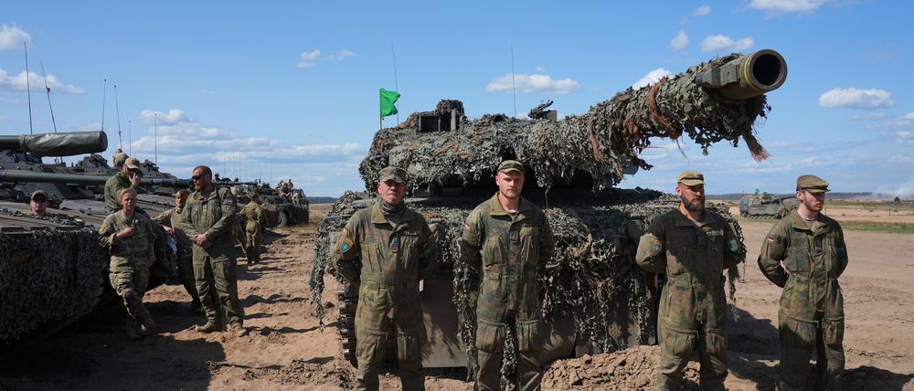 Die deutsche Besatzung eines Kampfpanzers Leopard 2A6 steht auf einem Truppenübungsplatz in Litauen