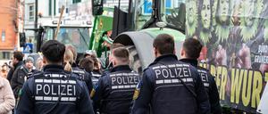 Polizisten gehen während einer Demonstration vor Beginn des politischen Aschermittwochs der baden-württembergischen Grünen vor der Stadthalle in Biberach an der Riß.