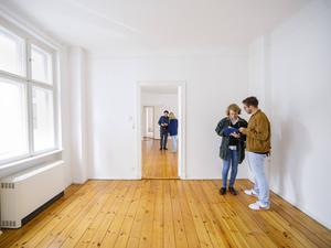 Gestellte Aufnahme zum Thema Wohnungsbesichtigung. Menschen schauen sich eine Altbauwohnung an. 