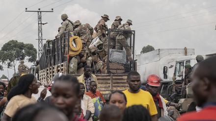 Uniformierte fahren mit einem Auto auf einer Straße in Goma.