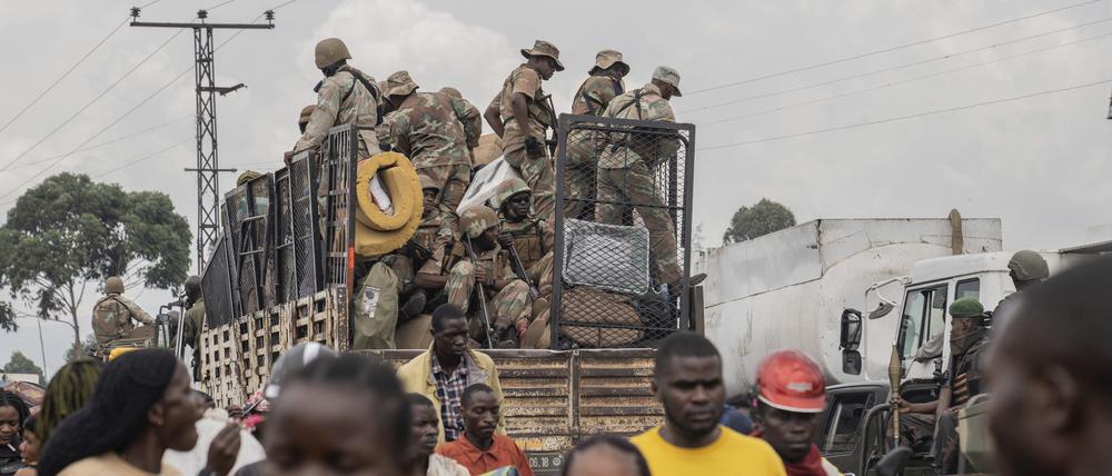 Uniformierte fahren mit einem Auto auf einer Straße in Goma.
