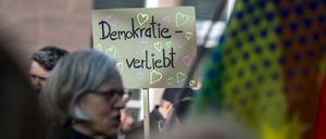 Eine Teilnehmerin einer Demonstration hält am Hauptbahnhof ein Schild mit der Aufschrift «Demokratie verliebt» hoch. 