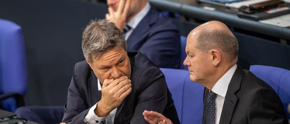 Bundeskanzler Olaf Scholz (SPD, r.), unterhält sich mit Wirtschaftsminister Robert Habeck (Bündnis 90/Die Grünen, M.).