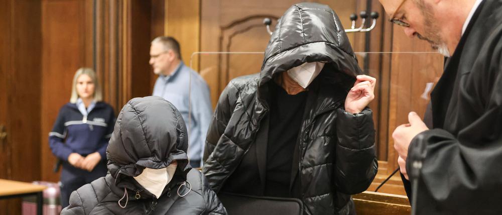 Die beiden Angeklagten kommen mit Kapuzen auf den Köpfen neben dem Anwalt Lutz Adam (r.) in den Verhandlungssaal. 