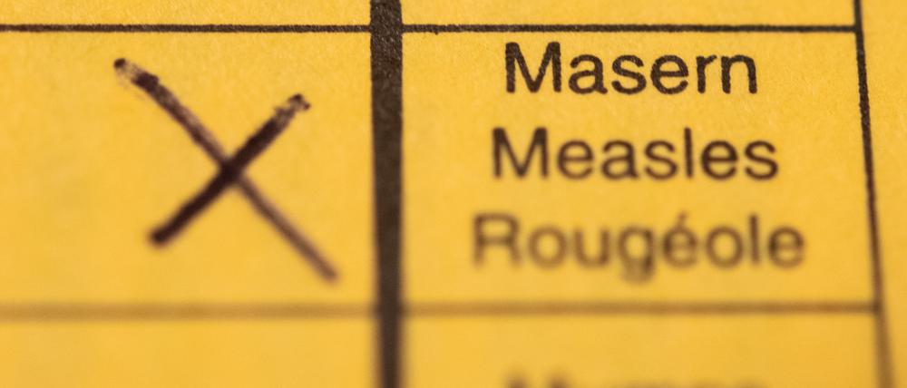 Ein Impfpass mit einem Kreuz bei der Masern-Impfung liegt auf einem Tisch. (Symbolbild)