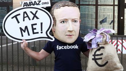Mark Zuckerberg soll in Europa Steuern zahlen. Dafür setzt sich ein Demonstrant in Brüssel ein.