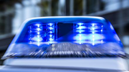 Das Blaulicht an einem Polizeiwagen ist eingeschaltet.
