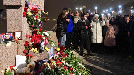 Menschen in St. Petersburg an einer Gedenkstelle für Opfer politischer Repression.