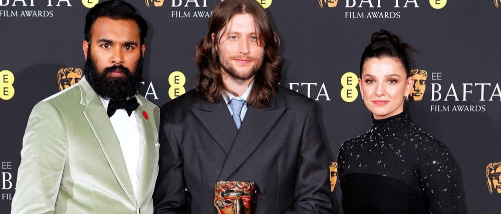 Ludwig Göransson (M), Komponist und Songwriter aus Schweden, steht im Presseraum neben den Preisverleihern Himesh Patel und Marisa Abela nach dem Gewinn des Preises für die Originalmusik für Oppenheimer bei den Bafta Film Awards 2024 in der Royal Festival Hall, Southbank Centre. Die British Academy of Film and Television Arts (BAFTA) ehrt mit diesen internationalen Preisen Leistungen in den Kategorien Spiel- und Kurzfilm.