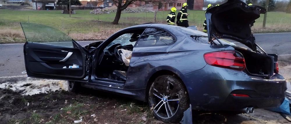 18.02.2024, Brandenburg, Kremmen: Ein Auto steht nach einem Unfall schwer beschädigt an einem Baum an einer Landstraße.  Eine 95 Jahre alte Frau ist am Sonntagnachmittag bei dem Autounfall nahe Kremmen (Landkreis Oberhavel) ums Leben gekommen. Das Auto, in dem sie als Beifahrerin unterwegs gewesen war, prallte gegen einen Baum, wie die Polizei am Abend mitteilte. Foto: Christian Pörschmann/-/ +++ dpa-Bildfunk +++