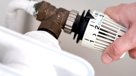 Eine Frau dreht am Thermostat einer Heizung. In Hessen sind fast 35 000 Anträge von Privathaushalten für Heizkosten-Härtefallhilfen eingegangen.