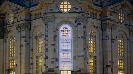 An der Fassade der Frauenkirche in Dresden hängt ein Banner mit der Botschaft „Wir haben die Wahl – Für Demokratie gegen Rechtspopulismus“.