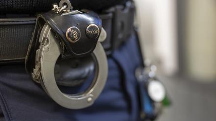 Eine Handschelle hängt am Gürtel eines Polizisten. (Symbol)
