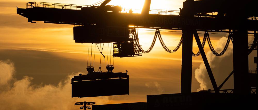 Container werden bei Sonnenaufgang am Terminal Burchardkai verladen. 