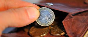 Eine Hand nimmt am 22.01.2010 eine Euro-Münze aus einem Geldbeutel, in dem sich weitere Münzen befinden. 