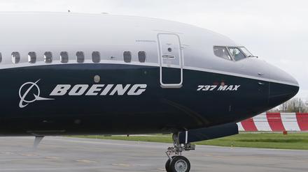 Ein Pilot winkt aus der Pilotenkabine eines Flugzeuges vom Typ Boeing 737 MAX 9 auf dem Flughafen. 