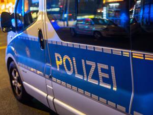 Ein Polizeifahrzeug steht bei einem Einsatz in der Nacht auf der Straße. (Symbolbild)