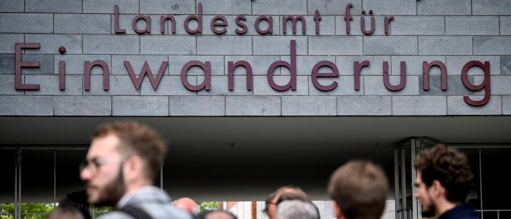 Menschen stehen vor dem Berliner Landesamt für Einwanderung.