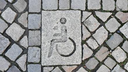 ARCHIV - 05.02.2020, Brandenburg, Potsdam: Die Kennzeichnung eines Behindertenparkplatzes ist in der Innenstadt in das Straßenpflaster integriert. Oftmals scheuen Menschen mit Behinderung den Weg zur Polizei, wenn sie angegriffen wurden. (zu dpa: «Gleichbleibende Zahl von Straftaten gegen Menschen mit Behinderung») Foto: Jens Kalaene/dpa-Zentralbild/dpa +++ dpa-Bildfunk +++