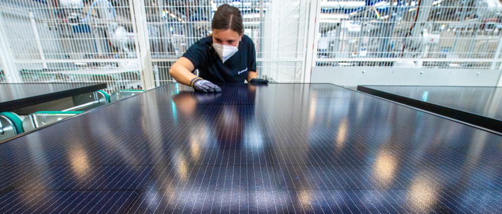 Eine Mitarbeiterin begutachtet im Werk der Meyer Burger Technology AG in Freiberg ein Solarmodul.