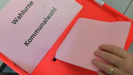 Eine Wählerin steckt ihren Stimmzettel zur Kommunalwahl in Brandenburg in die Wahlurne. 
