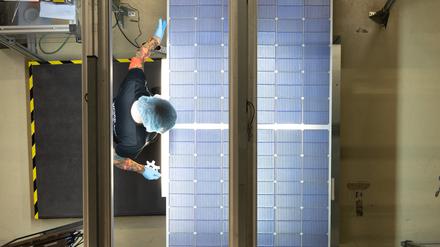 Eine Mitarbeiterin steht bei der Qualitätskontrolle an einer Produktionslinie für Solarmodule im Werk der Meyer Burger Technology AG.