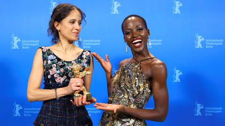 French-Senegalese filmmaker and actress Mati Diop (L) poses with the Golden Bear for Best Film for the film "Dahomey" with Kenyan-Mexican actress and President of the International Jury 2024 Lupita Nyong‘o back stage during the awards ceremony of the 74th Berlinale International Film Festival, on February 24, 2024 in Berlin. (Photo by NADJA WOHLLEBEN / POOL / AFP)