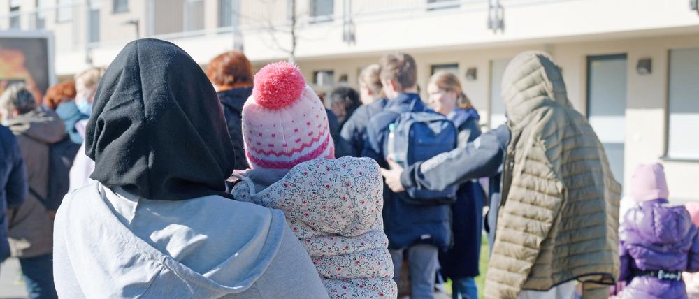 Geflüchtete aus der Ukraine stehen vor den Gebäuden einer Flüchtlingsunterkunft. 