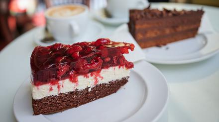 Zwei Stück Torte und zwei Cappuccini stehen auf dem Tisch.