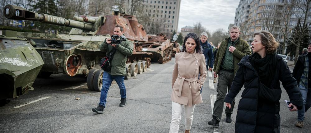 Annalena Baerbock geht bei ihrem Besuch des ehemaligen Sitz der Regionalverwaltung der Oblast Mykolajiw an zerstörten russischen Panzern vorbei.