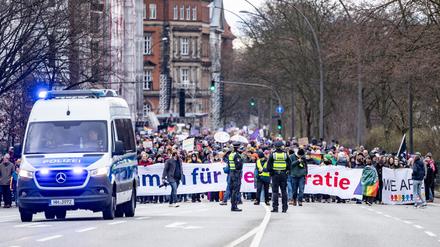 Teilnehmer der Demonstration gegen rechts halten Banner mit der Aufschrift „Zusammen für Demokratie“ in die Höhe.