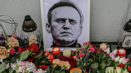 Flowers, candles, and a portrait of Alexei Navalny, who died in prison, are placed near the walls of the Russian Embassy in Warsaw.