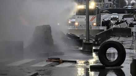 Belgische Polizisten setzen einen Wasserwerfer bei einem Bauernprotest in Brüssel ein.