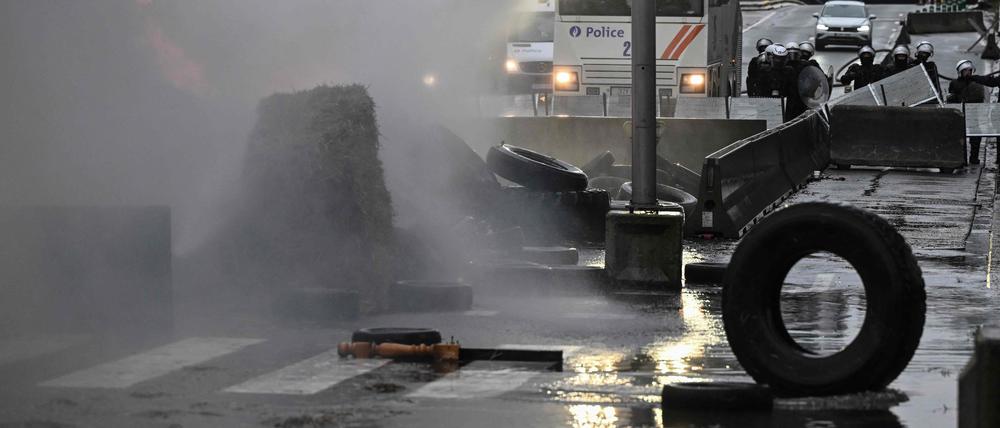 Belgische Polizisten setzen einen Wasserwerfer bei einem Bauernprotest in Brüssel ein.