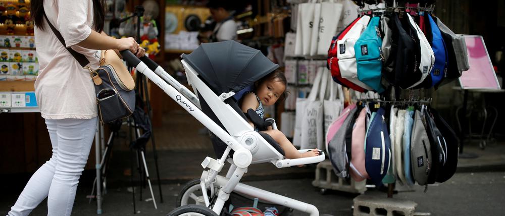 Eine Frau schiebt einen Kinderwagen in Seoul. Nirgendwo auf der Welt ist die Geburtenrate so niedrig wie in Südkorea.