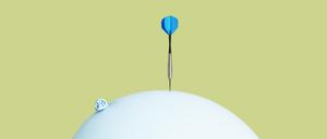 Ein Dartpfeil trifft auf einen Luftballon.