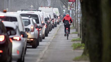 Radfahrer fahren an der Bundesstrasse 105 in der Rostocker City entlang am Stau im Berufsverkehr. 