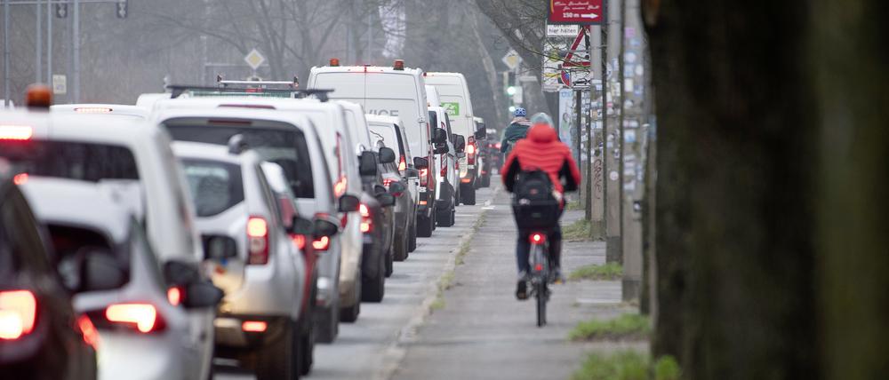 Radfahrer fahren an der Bundesstrasse 105 in der Rostocker City entlang am Stau im Berufsverkehr.
