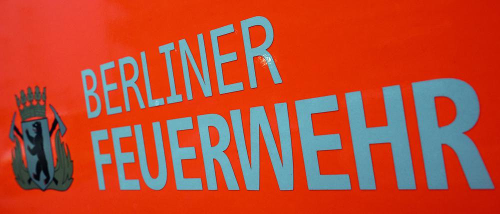 Der Schriftzug und das Wappen der Berliner Feuerwehr mit dem Berliner Bären stehen auf der Tür eines Feuerwehrfahrzeuges.