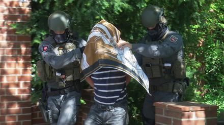 Polizisten führen einen Verdächtigen ab. Rund sieben Monate nach seinem vermeintlichen Ertrinken in der Ostsee hatten Ermittler den Kieler im Dezember 2019 auf dem Dachboden im Haus seiner Mutter entdeckt.