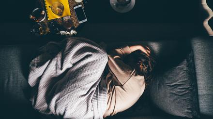 Eine Frau liegt erschöpft auf dem Bett