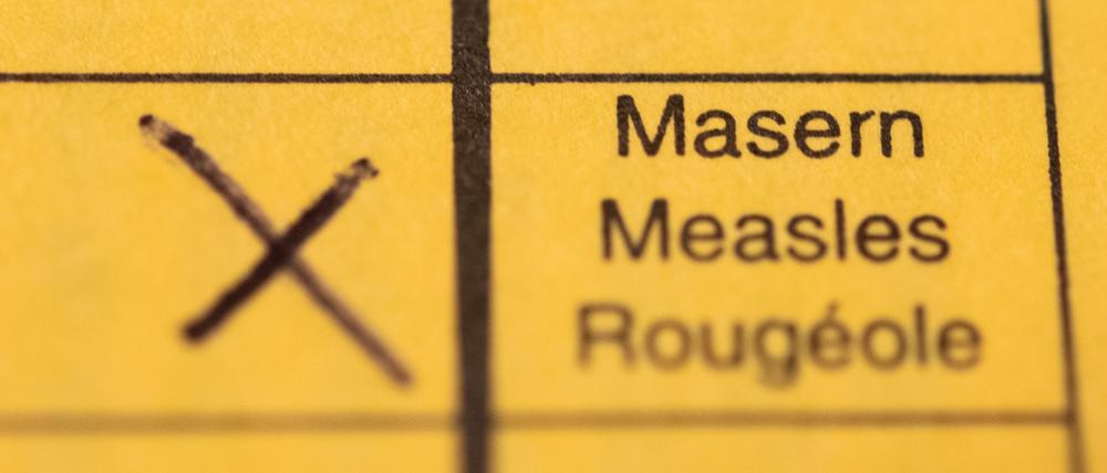 ARCHIV - 29.02.2020, Baden-Württemberg, Stuttgart: ILLUSTRATION - Ein Impfpass mit einem Kreuz bei der Masern-Impfung liegt auf einem Tisch. (zu dpa: «Masernausbruch im Vogtland - Kinder waren nicht ausreichend geimpft») Foto: Tom Weller/dpa +++ dpa-Bildfunk +++
