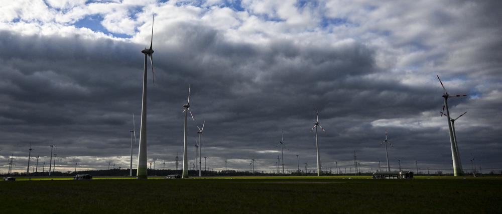 ARCHIV - 03.04.2023, Brandenburg, Wustermark: Windräder werden bei wolkigem Himmel kurzzeitig von der tiefstehenden Sonne beleuchtet. (zu dpa: «Wechselhaftes Wetter am Wochenende in Berlin und Brandenburg») Foto: Jens Kalaene/dpa +++ dpa-Bildfunk +++
