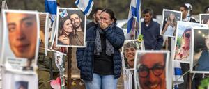 Eine Frau inmitten von Fotos von Hamas-Geiseln bei einer Veranstaltung auf dem Gelände des Supernova-Festivals. 