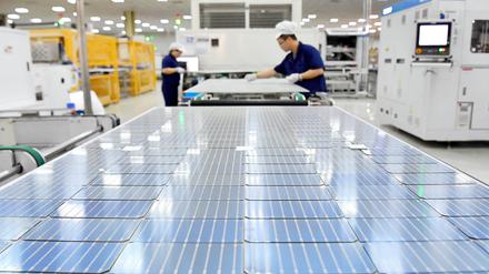 Zwei Arbeiter sind in einer Fabrik des chinesischen Solarpanel-Herstellers Longi Green Energy Technology zu sehen.